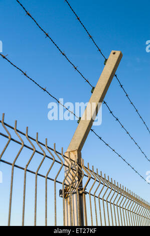 La sicurezza del filo spinato contro il cielo blu Foto Stock