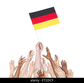 Mano umana tenendo la Germania bandiera tra multi-etnico gruppo di persone la mano Foto Stock