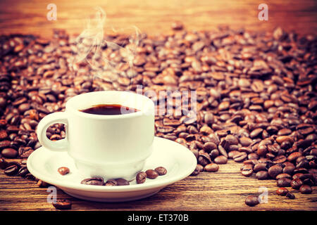 Retrò coppa nei toni del nero caffè caldo sul tavolo di legno, la profondità di campo. Foto Stock