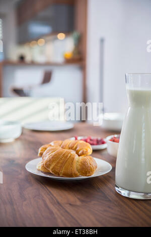 Cornetti e latte per la colazione al tavolo da pranzo, Monaco di Baviera, Germania Foto Stock