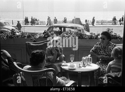 Holiday scene. in Hastings, East Sussex. I villeggianti gustando un tè pomeridiano in un caffè sul mare. Giugno 1952. Foto Stock