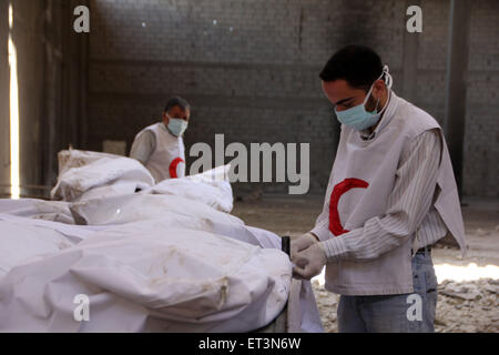 Bustan Al-Qasr, Aleppo, Siria. 11 Giugno, 2015. Red Crescent lavoratori ispezionare i corpi dei morti i combattenti fedeli al Presidente siriano Bashar al-Assad durante uno scambio di corpi morti tra il libero esercito siriano e il governo siriano forze, in m Bustan al-qasr quartiere a est del nord della città siriana di Aleppo a giugno 11, 2015 Credit: Ameer Al-Halbi APA/images/ZUMA filo/Alamy Live News Foto Stock