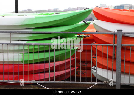 Canoe impilati pronti per il prossimo i turisti a Newquay Harbour in Cornovaglia Foto Stock