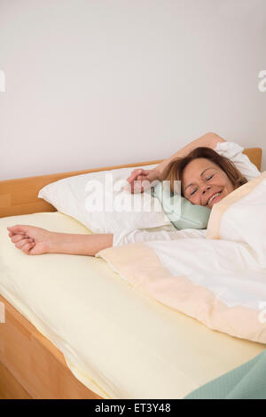 Senior donna che dorme nella sua camera da letto, Monaco di Baviera, Germania Foto Stock