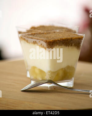 Apple Crumble dessert servito su un tavolo di legno. Foto Stock