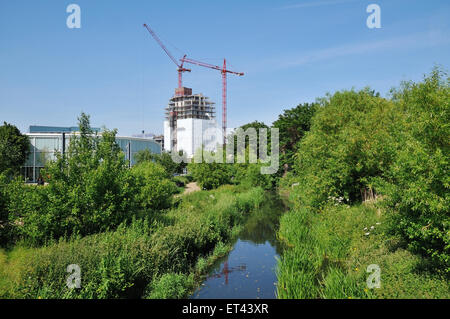 Ravensbourne River, Lewisham, a sud-est di Londra, con blocco di appartamenti in costruzione Foto Stock