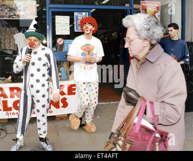 Karaoke clown Peter Watson (a destra) e Stephen Brooks intrattenere shopper in Stockton. Il 15 marzo 1995. Foto Stock