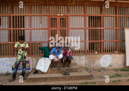 India lavoratori in fabbrica per prendersi una pausa all'ombra a Balaramapurum, un Indiano handloom colonia nell India meridionale Foto Stock