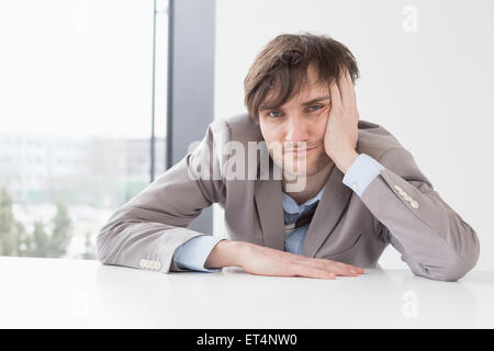 Uomo d'affari appoggiato alla scrivania in ufficio, Lipsia, Sassonia, Germania Foto Stock