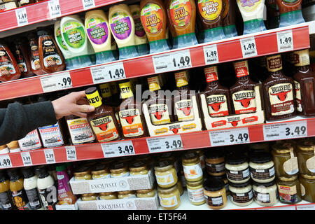 Germania - maggio 2015: i ripiani con varie salse barbecue in bottiglie in un supermercato Kaufland. Foto Stock