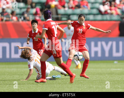 Edmonton, Canada. 11 Giugno, 2015. Della Cina di giocatore Ruyin Tan (1R) il sistema VIES per la palla con il Canada's player Danielle Van De Donk (inferiore) durante il gruppo una corrispondenza tra il Canada e la Cina al 2015 FIFA Coppa del mondo femminile in Edmonton, Canada, 11 giugno 2015. Credito: Qin Lang/Xinhua/Alamy Live News Foto Stock