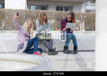 Gli amici utilizzando la tecnologia, Monaco di Baviera, Germania Foto Stock