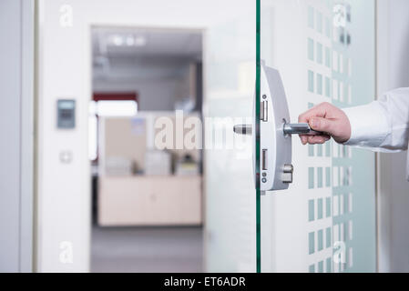 Uomo d'affari che apre la porta dell'ufficio, Monaco, Baviera, Germania Foto Stock