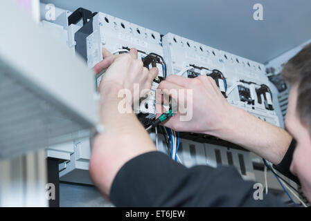 Elettricista cavo di fissaggio nella scatola dei fusibili di distribuzione, Monaco di Baviera, Germania Foto Stock