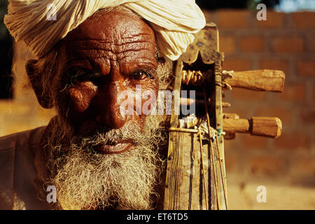 Musicista musulmano riproduzione di un tradizionale strumento musicale ( India) Foto Stock