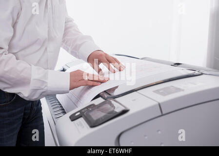 Uomo con fotocopiatrice in ufficio, Monaco di Baviera, Germania Foto Stock