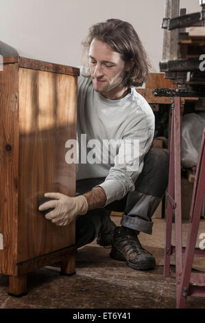 Carpenter lucidatura francese sul cassetto di legno in officina, Baviera, Germania Foto Stock