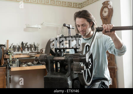 Il restauratore lavorando su una lamiera di laminatoio in officina, Baviera, Germania Foto Stock