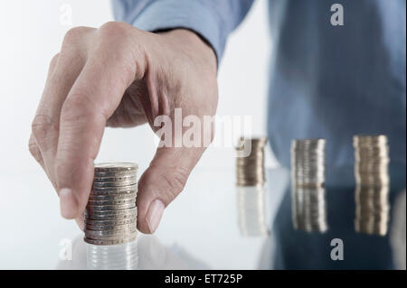 Mano d'uomo d'affari che impilava monete, Baviera, Germania Foto Stock