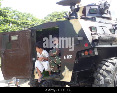 Manila, Filippine. 12 Giugno, 2015. Un ragazzo in appoggio sul serbatoio della marina militare filippino che viene visualizzata al Luneta Park durante la 117Independence Day celebrazione. Credito: Sherbien Dacalanio/Pacific Press/Alamy Live News Foto Stock