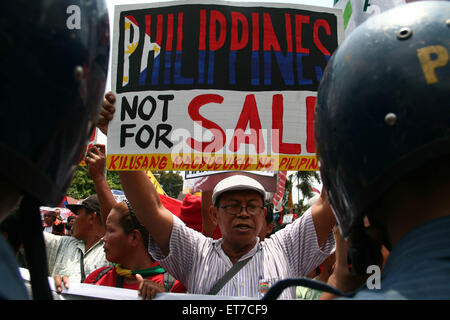 Manila, Filippine. 12 Giugno, 2015. Un manifestante tenendo un poster contro la presunta vendita delle Filippine per gli Stati Uniti Ci sono circa un migliaio di manifestanti hanno marciato per l ambasciata degli Stati Uniti in Roxas Boulevard a Manila, all'aria le loro rimostranze contro la presenza militare statunitense nelle Filippine. La marcia di protesta è tenuto in commemorazione del 117Giorno Di Indipendenza nelle Filippine. Credito: J Gerard Seguia/Pacific Press/Alamy Live News Foto Stock