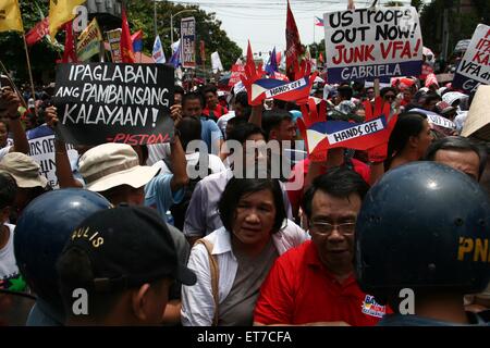 Manila, Filippine. 12 Giugno, 2015. I dimostranti provenienti da diversi gruppi di fronte la polizia di fronte all'ambasciata degli Stati Uniti come la chiamano per gli Stati Uniti di lasciare le Filippine da soli. Ci sono circa un migliaio di manifestanti hanno marciato per l ambasciata degli Stati Uniti in Roxas Boulevard a Manila, all'aria le loro rimostranze contro la presenza militare statunitense nelle Filippine. La marcia di protesta è tenuto in commemorazione del 117Giorno Di Indipendenza nelle Filippine. Credito: J Gerard Seguia/Pacific Press/Alamy Live News Foto Stock