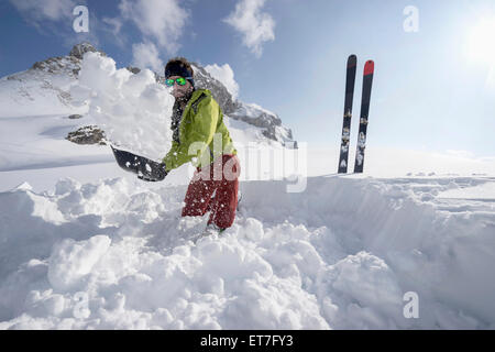 L'uomo spalare la neve per Bivacco accampamento, Tirolo, Austria Foto Stock