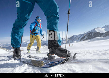 Chi pratica lo sci alpinismo arrampicata sulla montagna innevata in tempesta di neve, Zell Am See, Austria Foto Stock