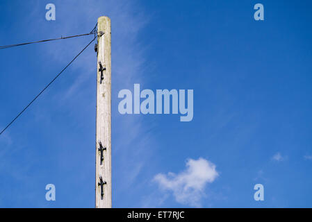 In legno palo del telegrafo contro un luminoso blu cielo con copyspace Foto Stock