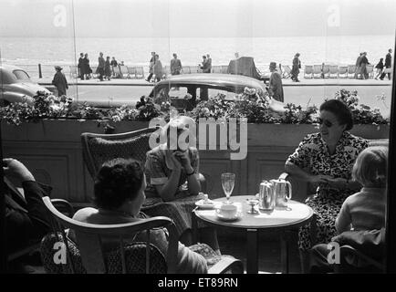 Holiday scene. in Hastings, East Sussex. I villeggianti gustando un tè pomeridiano in un caffè sul mare. Giugno 1952. Foto Stock