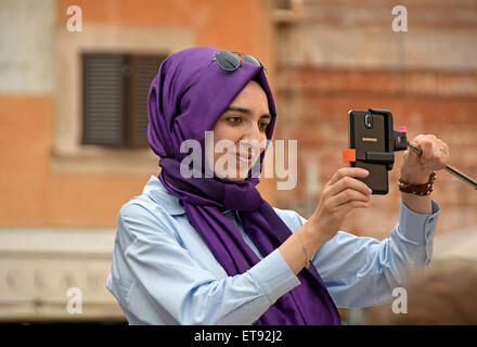 Una donna musulmana che indossa un viola l' hijab prende un selfie vicino al Pantheon di Roma, Italia Foto Stock