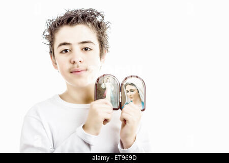 Un ragazzo ispanico contiene icone in legno case arrotondato di Gesù Misericordioso e la Madonna di Medjugorje, la Beata Vergine Maria Foto Stock