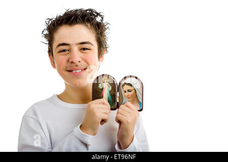 Un ragazzo ispanico contiene icone in legno case arrotondato di Gesù Misericordioso e la Madonna di Medjugorje, la Beata Vergine Maria Foto Stock