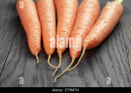 Le carote fresche sul vecchio tavolo in legno di quercia Foto Stock