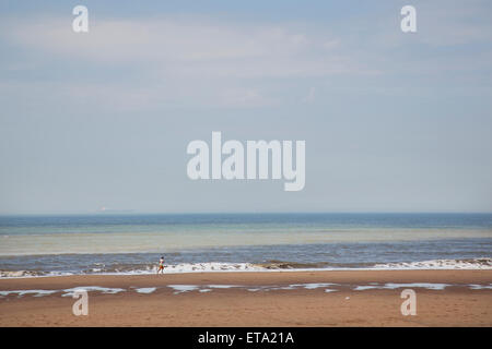 L'uomo corre sulla spiaggia del mare del Nord nei Paesi Bassi Foto Stock