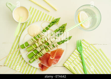 Spiedini di asparagi cotti al vapore avvolto con spaghetti con salsa olandese e prosciutto Foto Stock