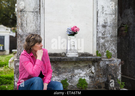 La donna nel centro storico di New Orleans cimitero. Copia spazio sulla cripta se necessario. Il lutto e ricordare. Foto Stock