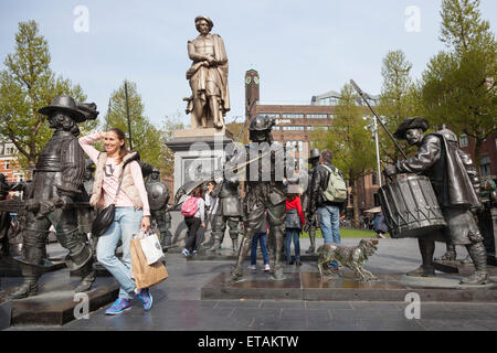 I turisti pongono di fronte di bronzo Ronda di Notte di Rembrandt sulla piazza di amsterdam Foto Stock