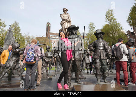 I turisti pongono di fronte di bronzo Ronda di Notte di Rembrandt sulla piazza di amsterdam Foto Stock