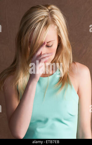 Triste giovane donna mano sulla testa Foto Stock