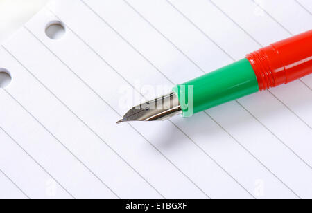 Penna stilografica senza cappuccio bianco su carta rigata Foto Stock