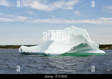 Bianco brillante iceberg sull' acqua scura e sfondo rock Foto Stock