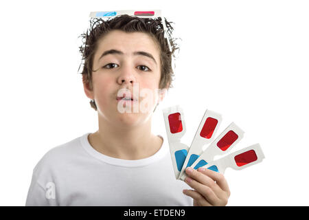 Un simpatico ragazzo caucasico indossa un paio di cinema 3D occhiali di carta sulla sua testa con il rosso e il blu cielo lenti e contiene altre 4 quelli con la mano sinistra Foto Stock