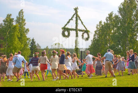 Persone in abiti estivi danza attorno al polo di mezza estate su Giugno 21, 2013 in Akersberga, Stoccolma, Svezia Foto Stock