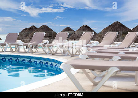 Lettini per prendere il sole vicino alla piscina del resort di lusso Foto Stock