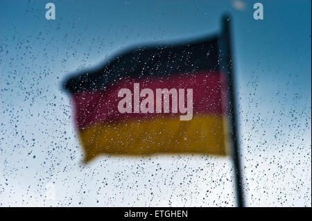Bandiera tedesca dietro un vetro con gocce di pioggia, Berlino Germania Europa Foto Stock