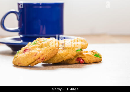 Un blu tazza da caffè con tre biscotti appena sfornati Foto Stock