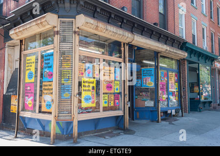 New York, Stati Uniti d'America. Xiii Giugno, 2015. I proprietari di Jesse's Deli in Boerum Hill quartiere di Brooklyn a New York il gesso le loro finestre con segni "yuppifying' comuni prodotti che vendono, visto il Sabato, 13 giugno 2015. Il deli è stato dato un passo affitto escursione e la re-branding è una protesta contro la passeggiata e il gentrifying dell'area. I nuovi prezzi rappresentano ciò che i clienti avrebbero dovuto pagare se ottengono un nuovo contratto di locazione con l'aumento del canone locativo. Credito: Richard Levine/Alamy Live News Foto Stock