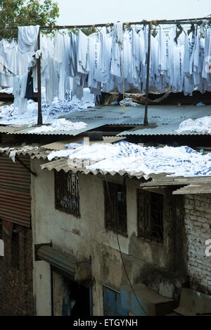 Panni lavati essiccazione su tetti di case a Mahalaxmi Dhobi Ghat aperto lavanderia a gettoni, Mumbai, Maharashtra, India. Foto Stock