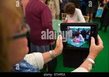 Pam Ayers poeta e autore libro firma mentre viene girato su un computer tablet con ventole in libreria a Hay Festival 2015 Foto Stock